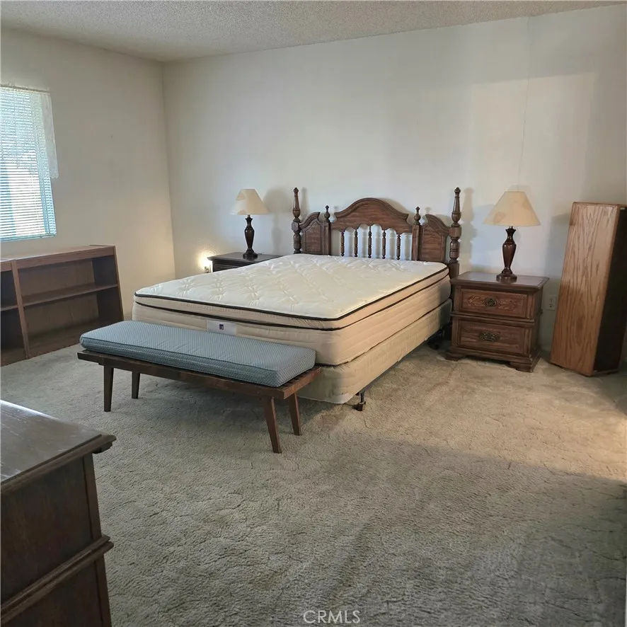 1536 South State Street, Unit 219 Hemet, CA 92543 - Photo 19 of 23 a spacious bedroom with a bed and a table in it