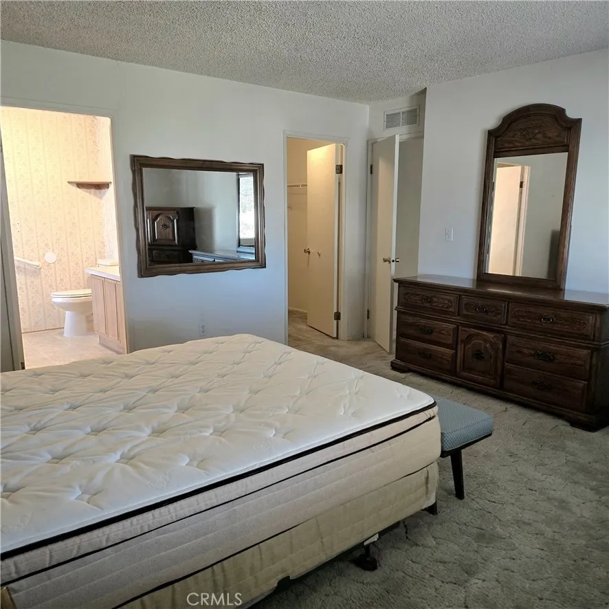 1536 South State Street, Unit 219 Hemet, CA 92543 - Photo 20 of 23 a bedroom with a bed and a mirror on dresser