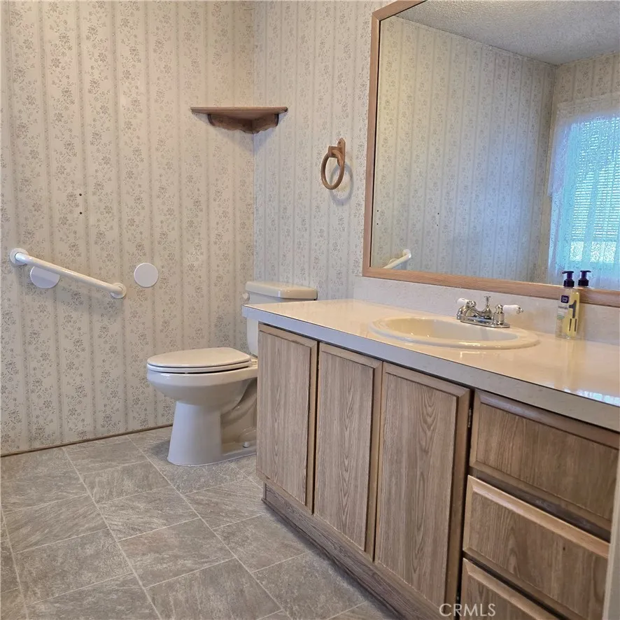 1536 South State Street, Unit 219 Hemet, CA 92543 - Photo 21 of 23 a bathroom with a sink a toilet and mirror