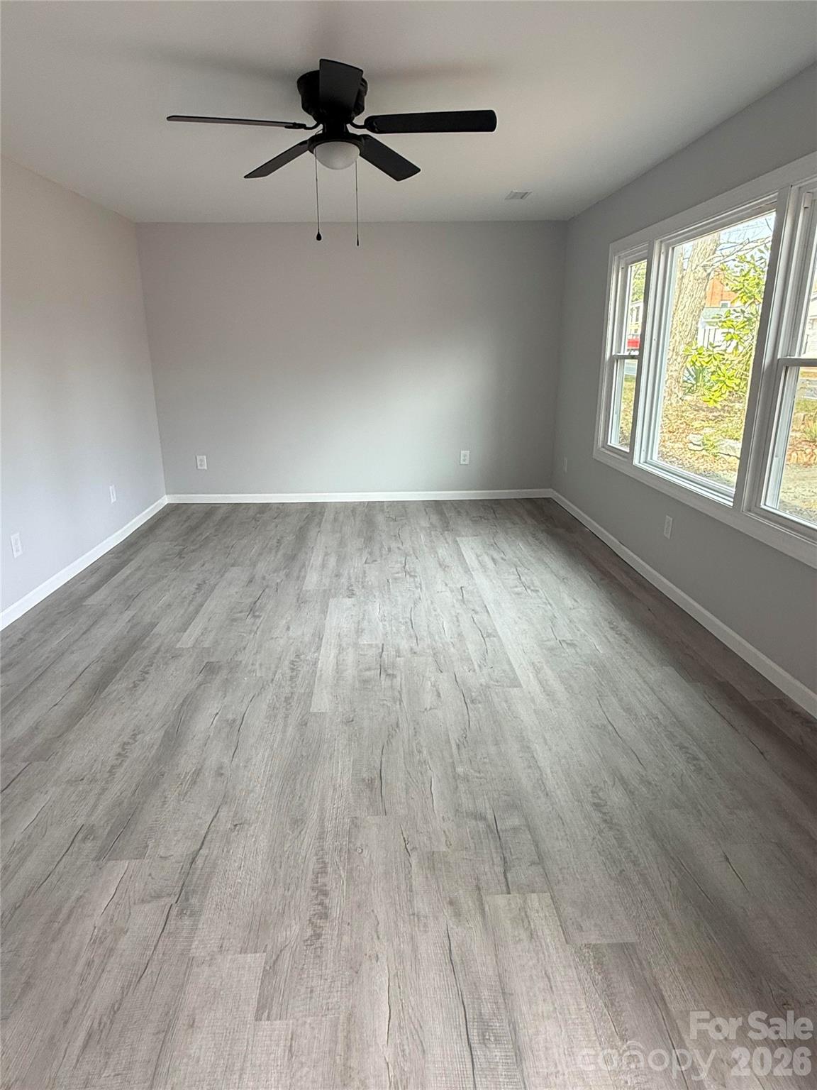 6457 Hudlow Road Union Mills, NC 28167 - Photo 2 of 14 an empty room with wooden floor fan and windows