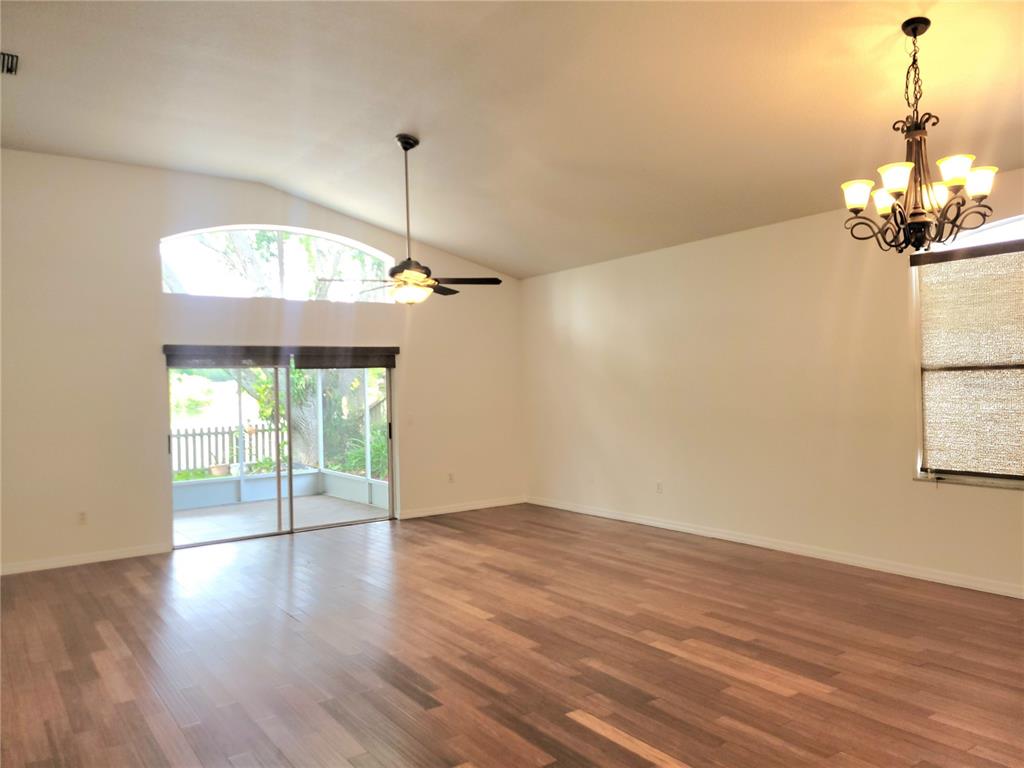 2011 Cattleman Drive Brandon, FL 33511 - Photo 11 of 40 an empty room with wooden floor chandelier fan and windows