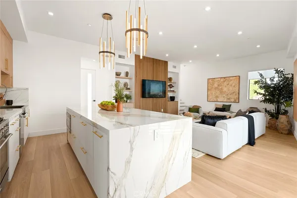 a large white kitchen with sink stove and refrigerator