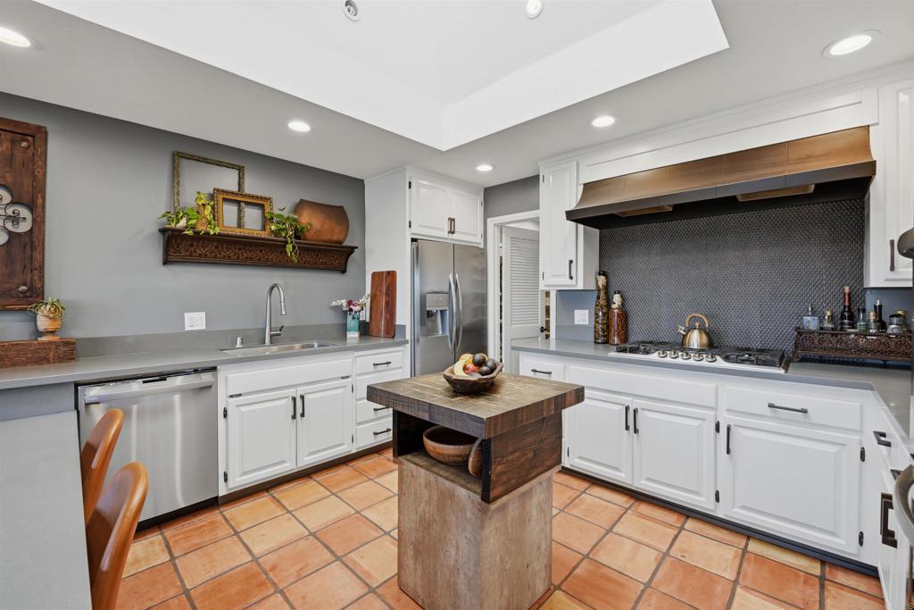 2414 Sacada Circle Carlsbad, CA 92009 - Photo 15 of 56 a kitchen with stainless steel appliances granite countertop a sink stove and cabinets