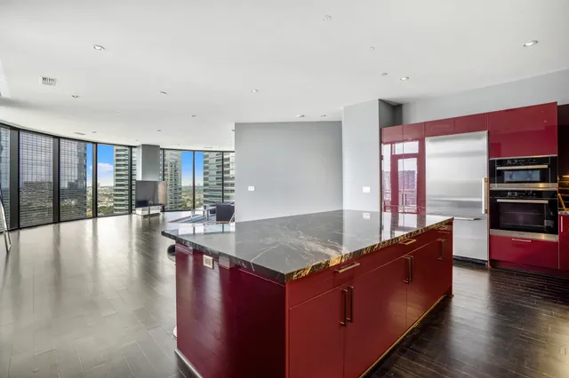 a living room with stainless steel appliances granite countertop a couch a table and chairs in it