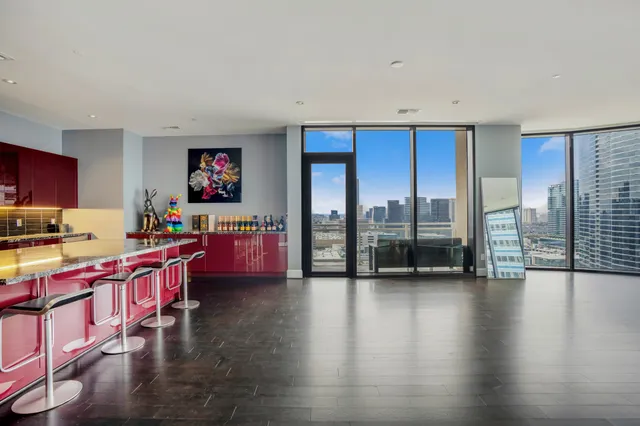 a kitchen with stainless steel appliances wooden floor and a view of living room