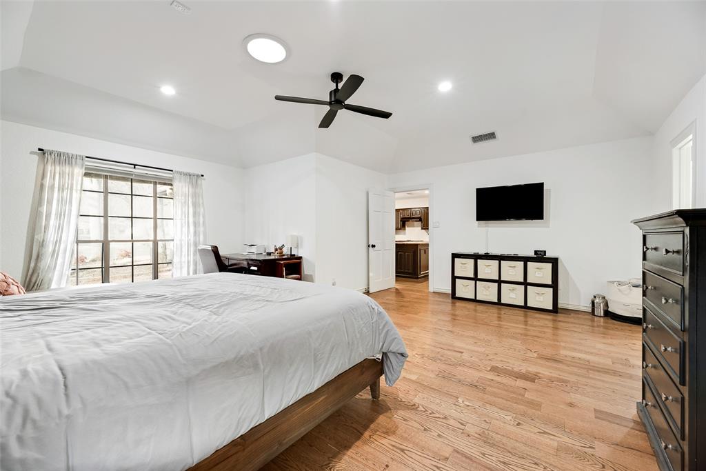 740 Newport Road Fort Worth, TX 76120 - Photo 19 of 38 a spacious bedroom with a bed and a flat screen tv