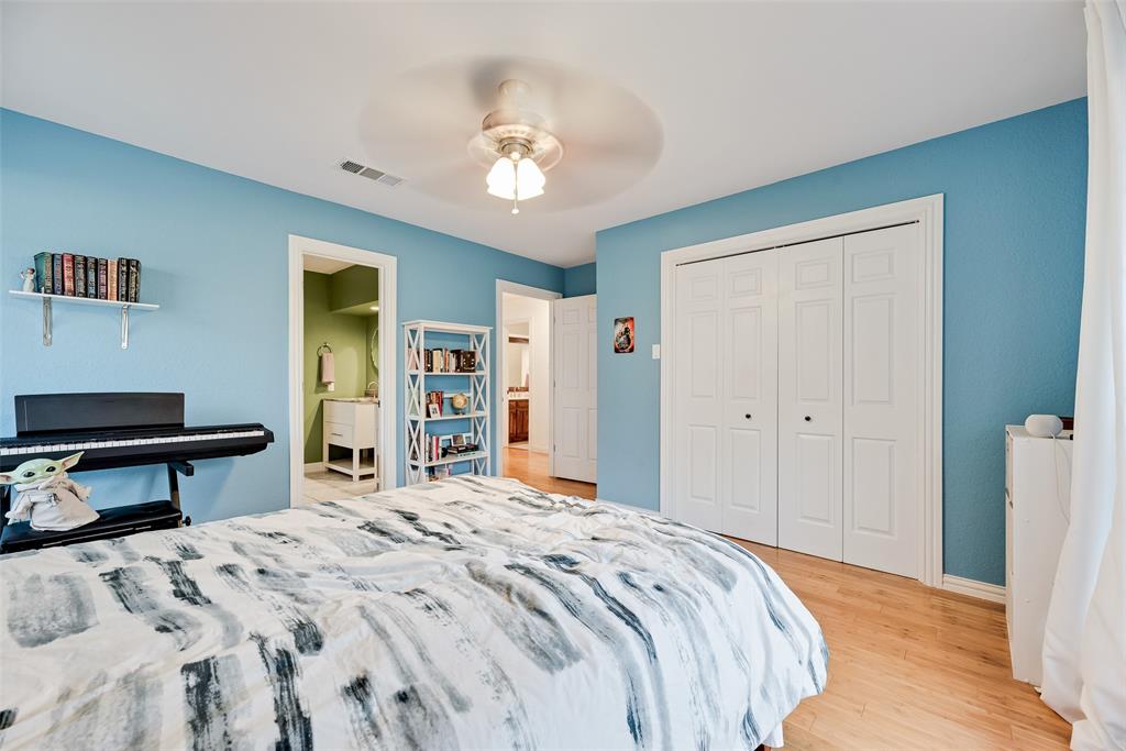 740 Newport Road Fort Worth, TX 76120 - Photo 27 of 38 a bedroom with a bed and a chandelier