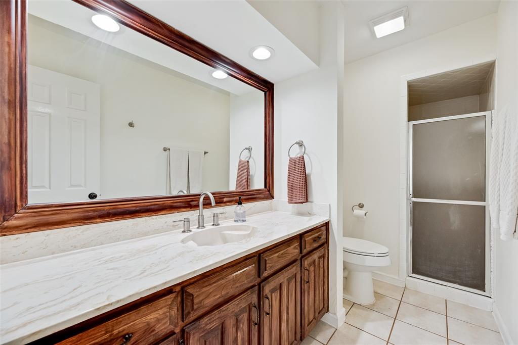 740 Newport Road Fort Worth, TX 76120 - Photo 32 of 38 a bathroom with a sink a toilet and a large mirror