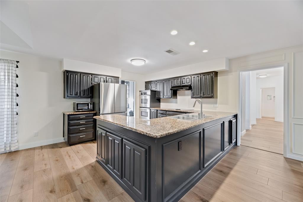 740 Newport Road Fort Worth, TX 76120 - Photo 9 of 38 a kitchen with stainless steel appliances granite countertop a kitchen island a stove a refrigerator and a sink