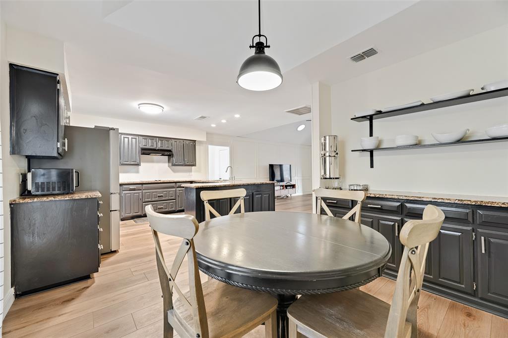 740 Newport Road Fort Worth, TX 76120 - Photo 10 of 38 a kitchen with stainless steel appliances kitchen island granite countertop a sink a stove a dining table and chairs
