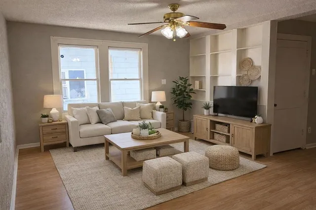 a living room with furniture a flat screen tv and a window