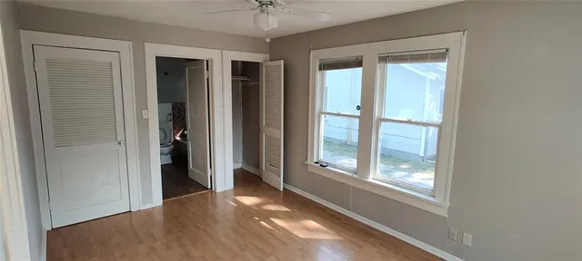 an empty room with windows and closet