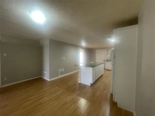 a view of a room with wooden floor and a window