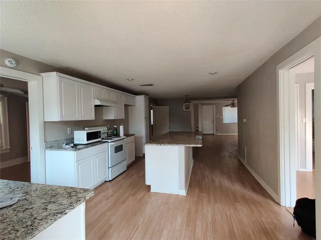 a kitchen with a sink wooden floor and stainless steel appliances