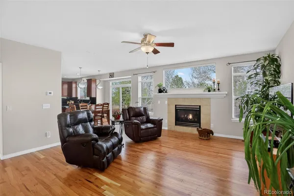 a living room with furniture a potted plant and a wooden floor