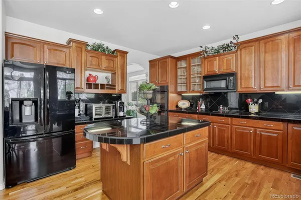 a kitchen with stainless steel appliances granite countertop a refrigerator and cabinets