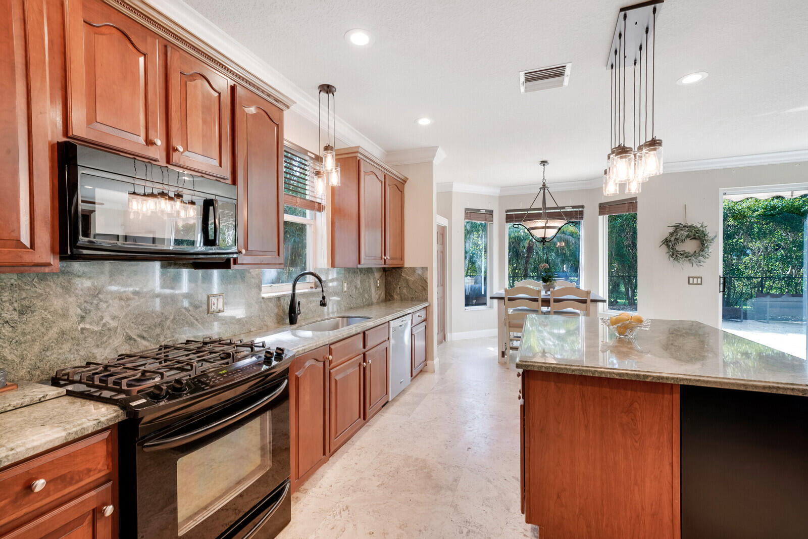 202 Anhinga Lane Jupiter, FL 33458 - Photo 11 of 40 a kitchen with stainless steel appliances granite countertop a stove a sink and a microwave
