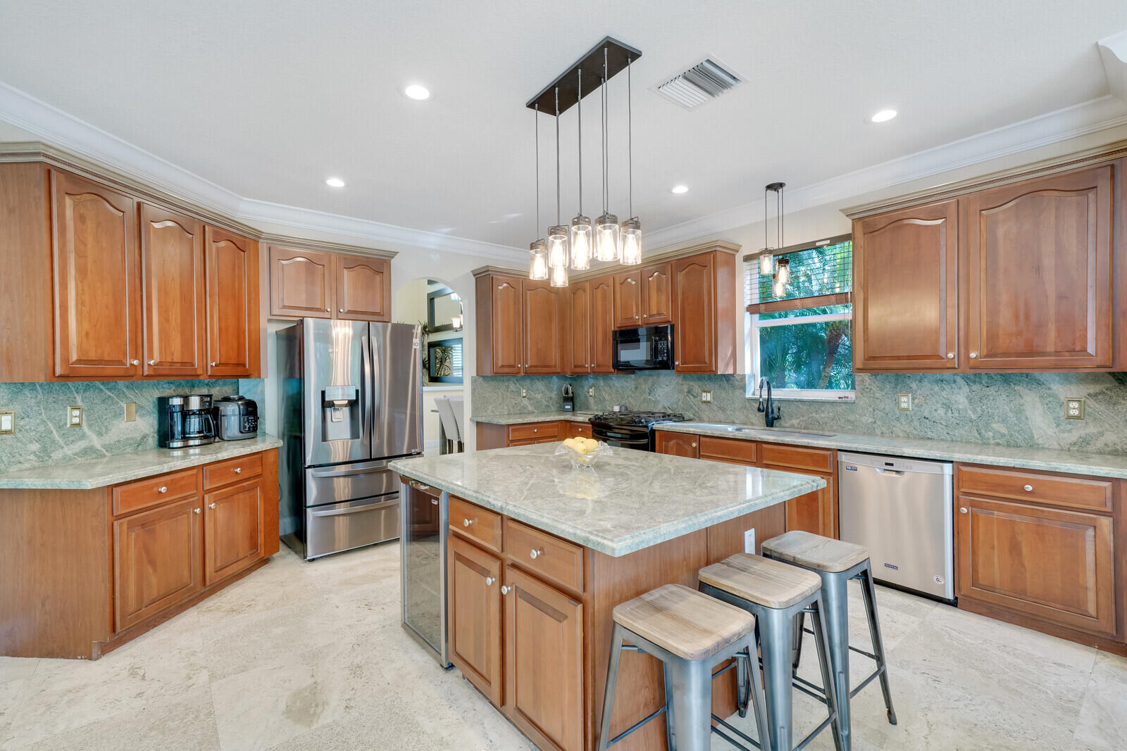 202 Anhinga Lane Jupiter, FL 33458 - Photo 13 of 40 a kitchen with stainless steel appliances granite countertop a kitchen island a stove a table and chairs in it