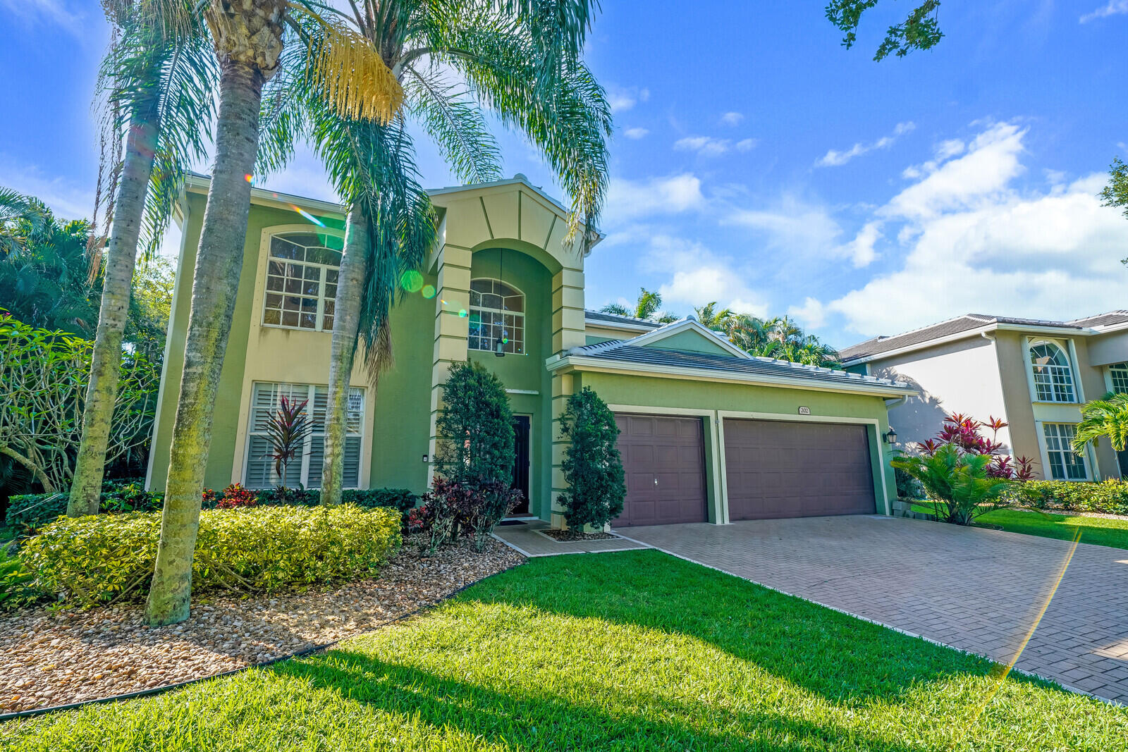 202 Anhinga Lane Jupiter, FL 33458 - Photo 3 of 40 front view of a house with a yard and potted plants