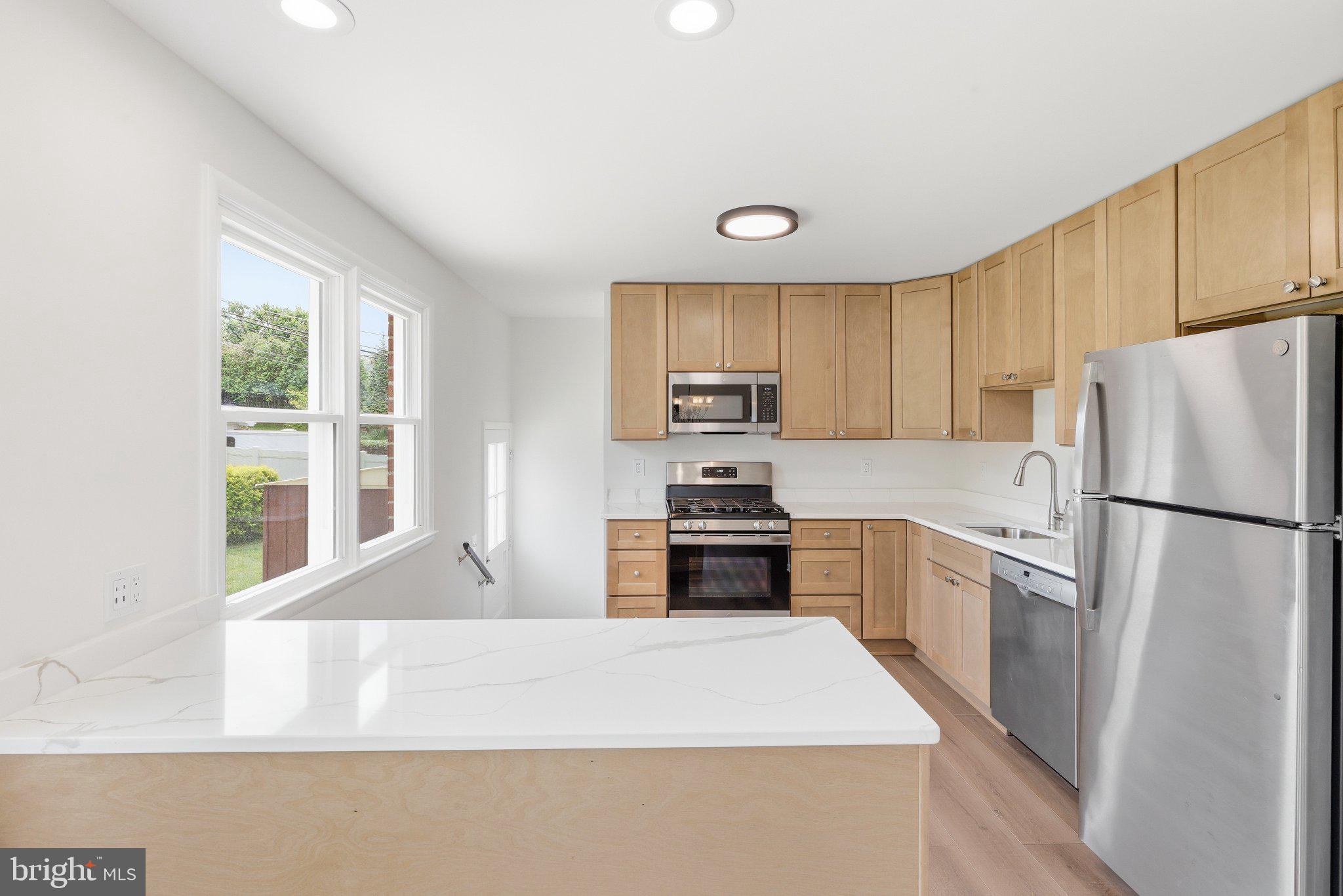 9005 Perring Park Road Baltimore, MD 21234 - Photo 6 of 20 a kitchen with granite countertop a refrigerator stove top oven and sink