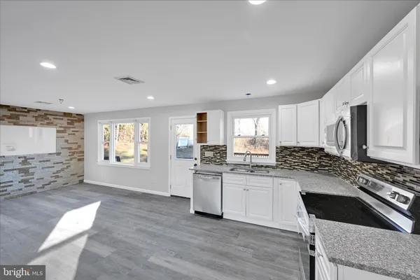 a kitchen with stainless steel appliances granite countertop a stove a sink and a refrigerator