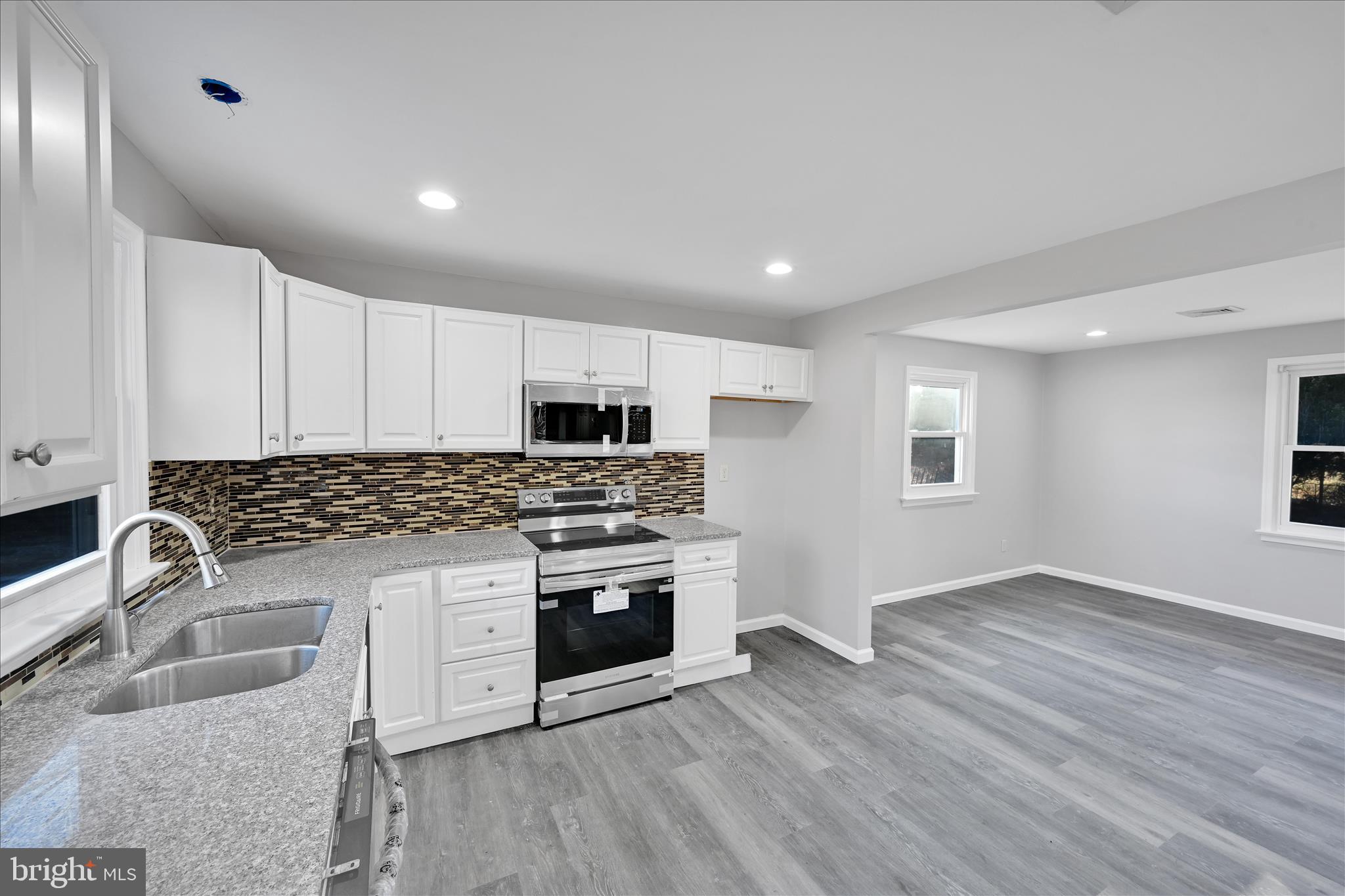 2509 Mill Road Mechanicsburg, PA 17055 - Photo 14 of 43 a kitchen with granite countertop a sink wooden floor and stainless steel appliances