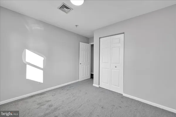 an empty room with windows and closet