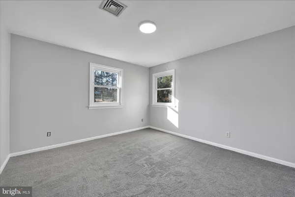 an empty room with windows and closet