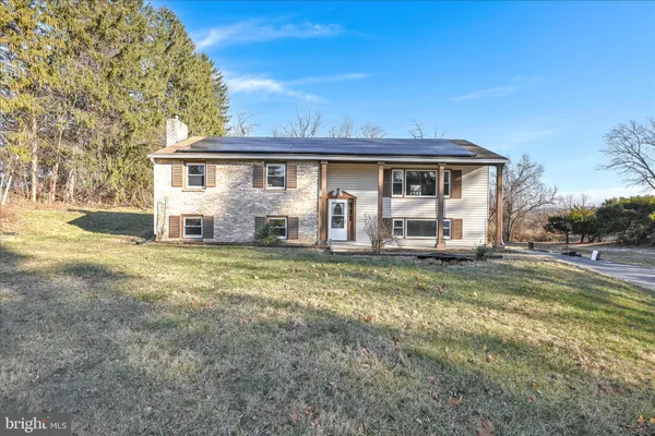 a view of a yard in front of a house with large trees