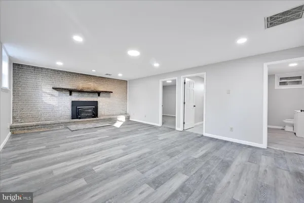 an empty room with wooden floor and a fireplace