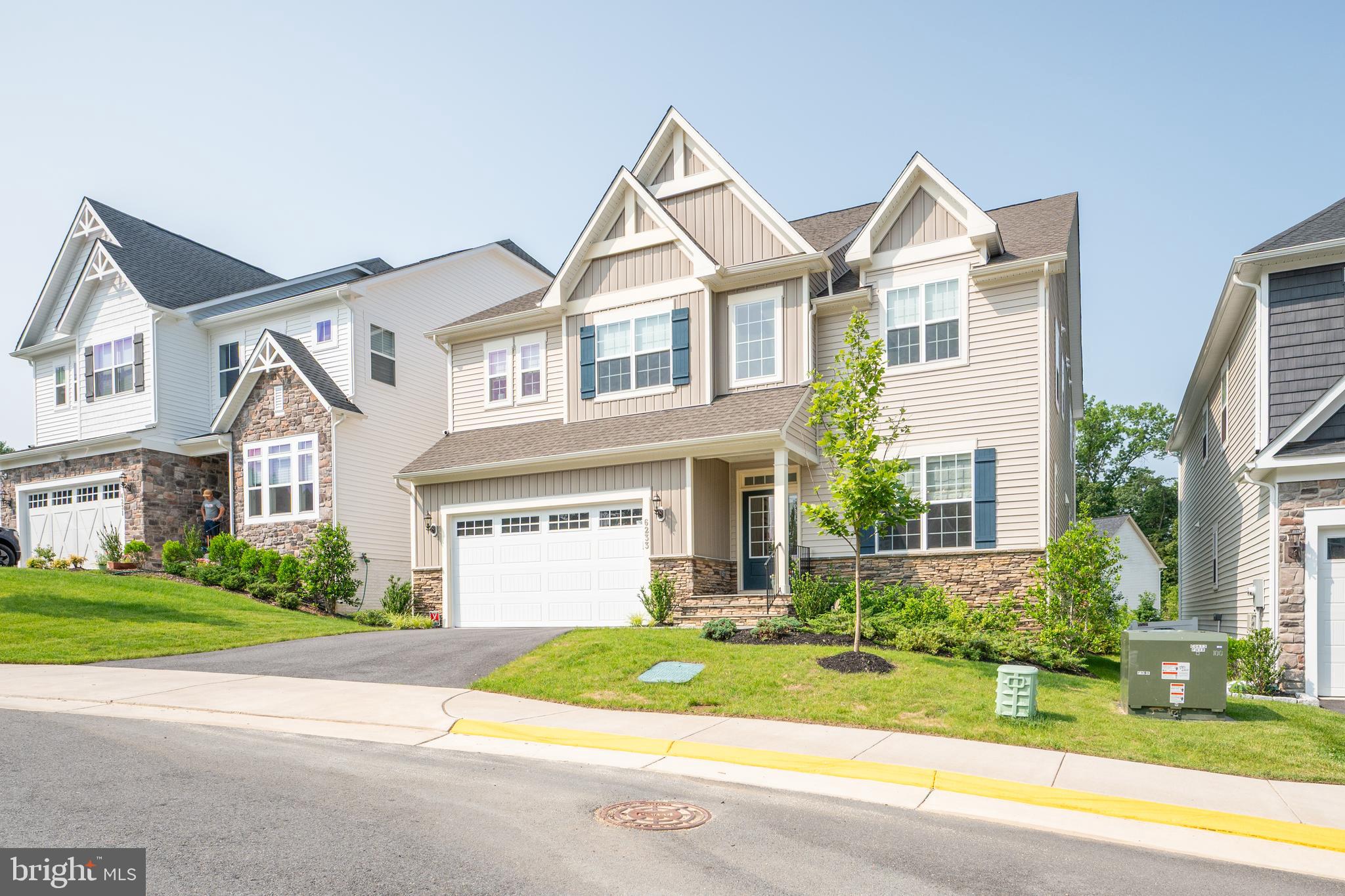 6233 McConnell Lane Springfield, VA 22152 - Photo 54 of 58 a view of a white house with a large windows and a yard with plants and large tree