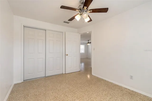 an empty room with chandelier fan