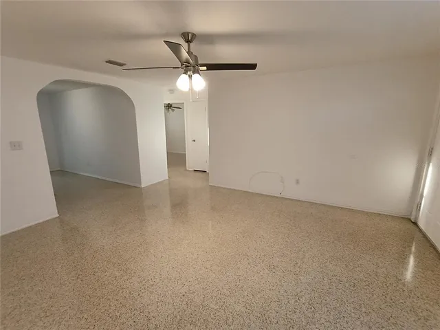 an empty room with a mirror and a fan