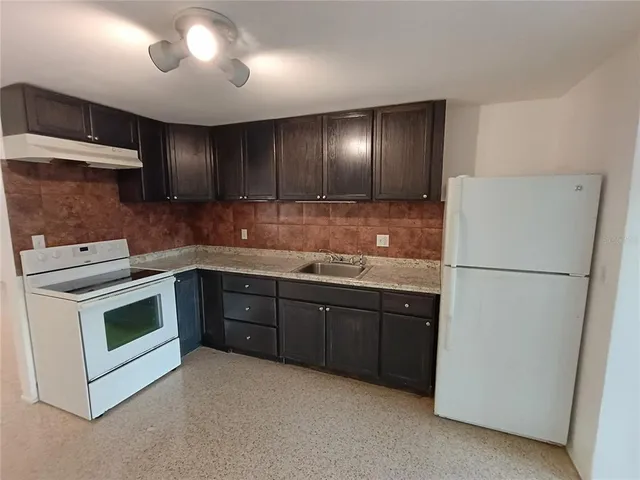 a kitchen with a sink a stove and cabinets