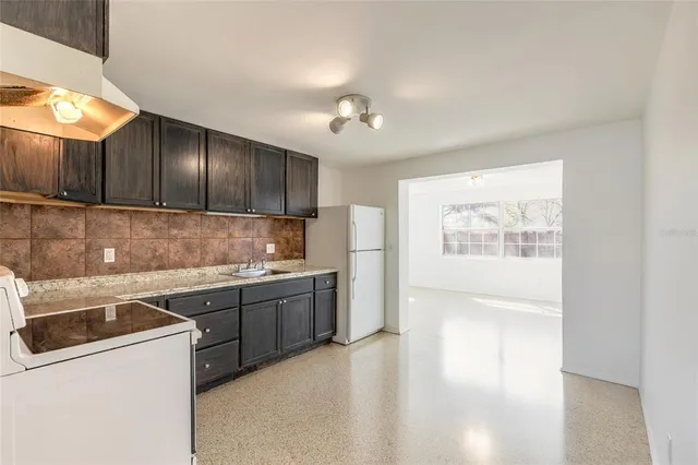 a kitchen with a sink a stove and cabinets