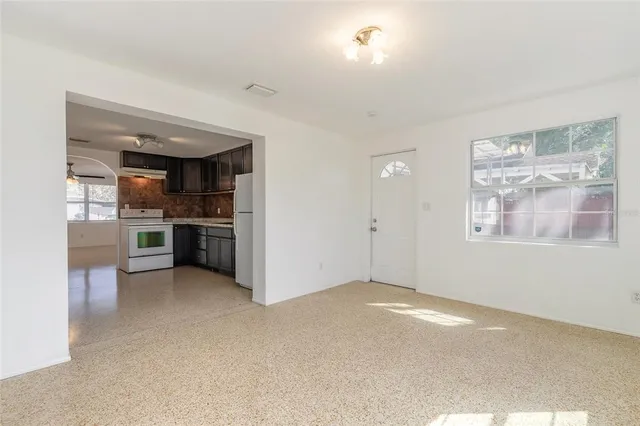 a view of an empty room with a kitchen