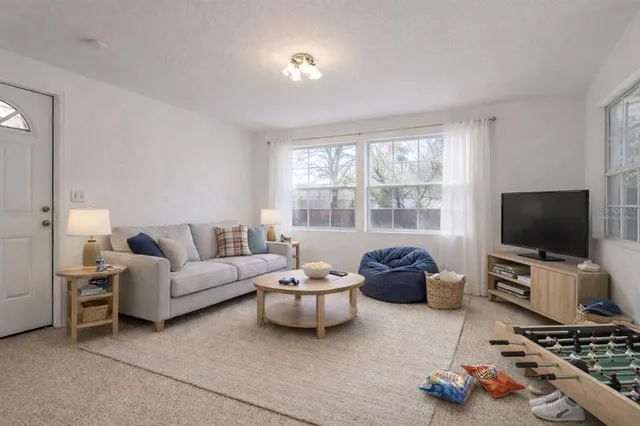 a living room with furniture a flat screen tv and a window