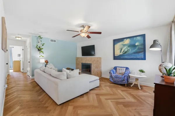 a living room with furniture a fireplace and a chandelier