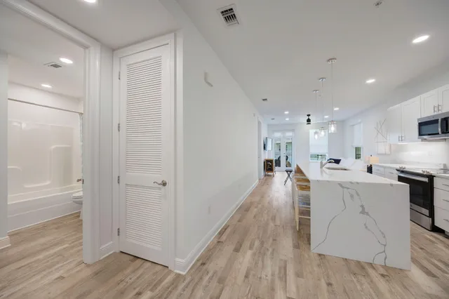 a kitchen with stainless steel appliances granite countertop a refrigerator a sink dishwasher and a stove with wooden floor