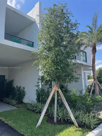 a view of a house with backyard and trees
