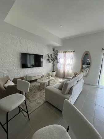 a kitchen with stainless steel appliances a sink a stove a microwave a refrigerator a stove and white cabinets