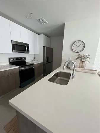 a kitchen with stainless steel appliances granite countertop a sink dishwasher stove top oven and refrigerator