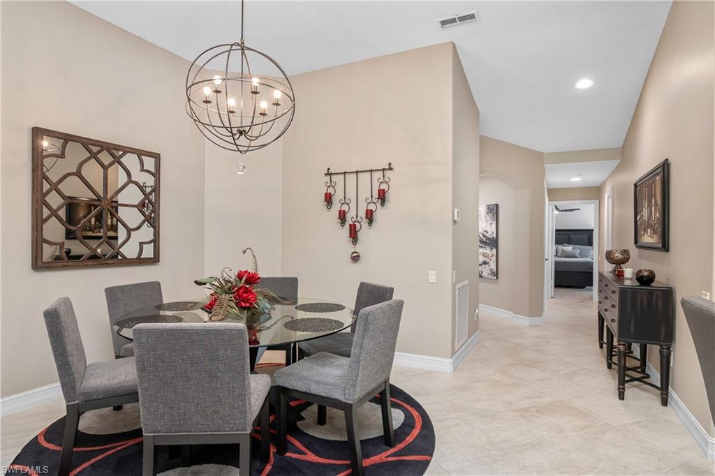 867 Carrick Bend Circle, Unit 2103 Naples, FL 34110 - Photo 12 of 32 a dining room with furniture a rug a chandelier and a window