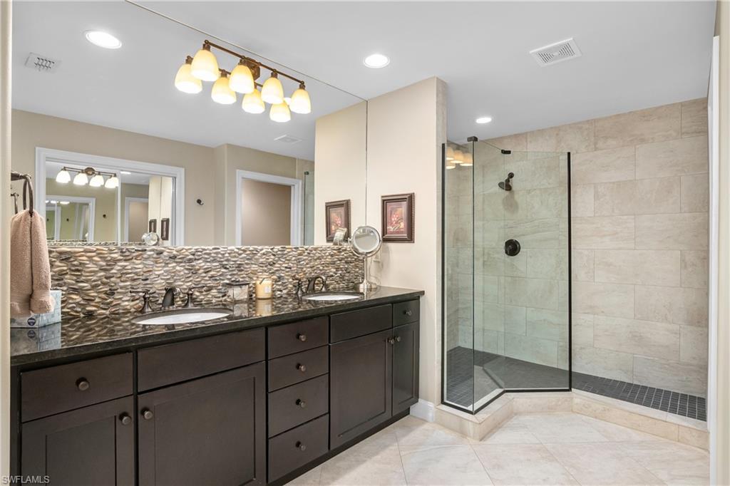 867 Carrick Bend Circle, Unit 2103 Naples, FL 34110 - Photo 17 of 32 a bathroom with a granite countertop sink mirror and shower