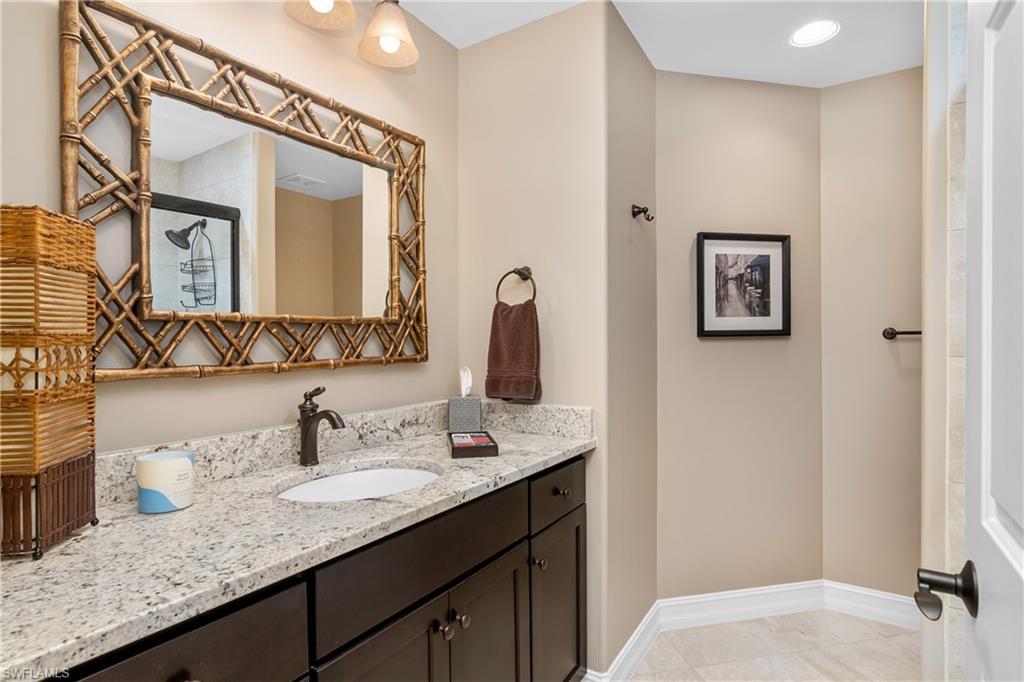 867 Carrick Bend Circle, Unit 2103 Naples, FL 34110 - Photo 20 of 32 a bathroom with a granite countertop double vanity sink and a mirror