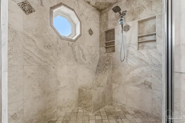 a bedroom with a large bed and a chandelier