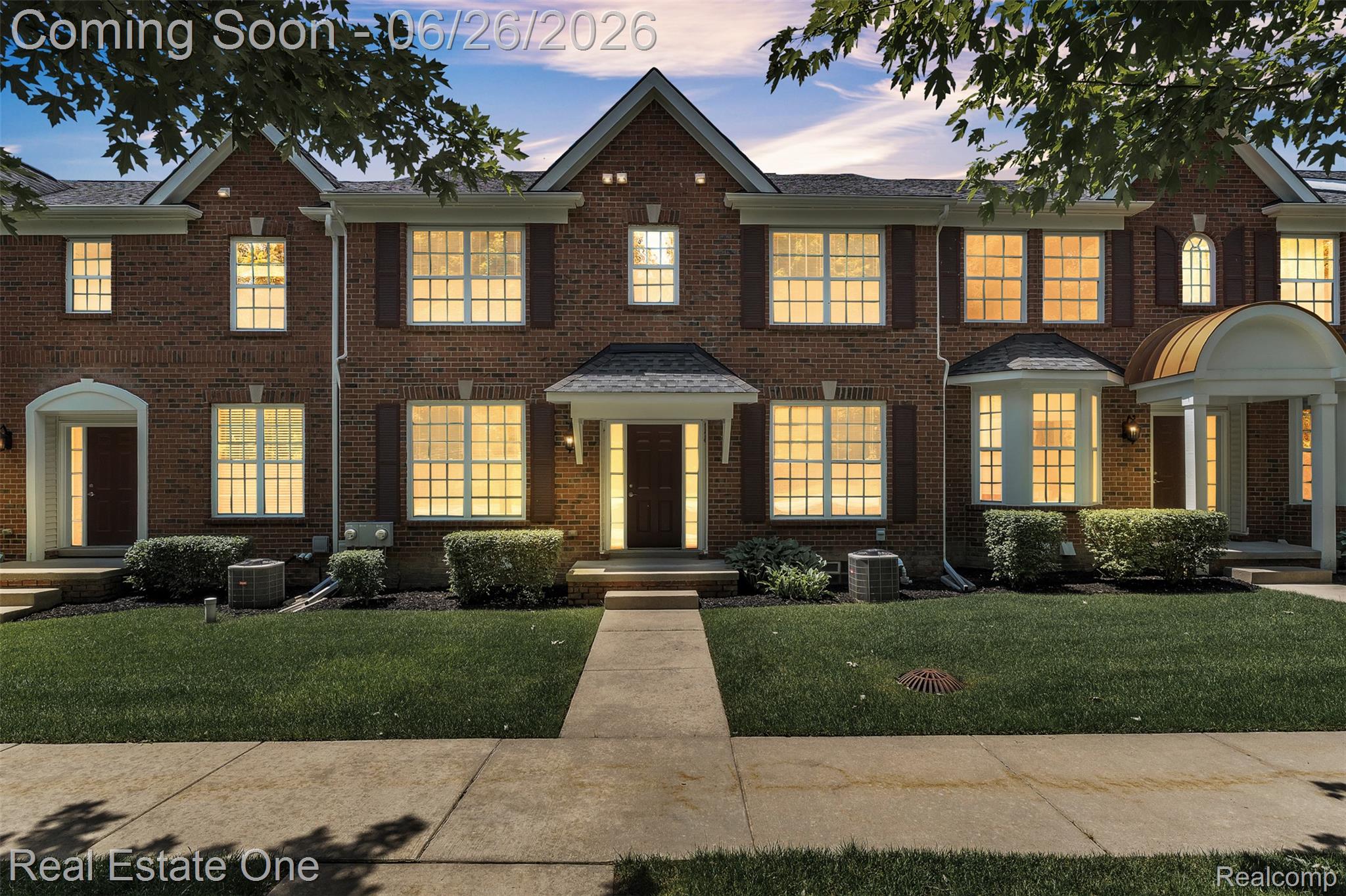 41590 Mitchell Road Novi, MI 48377 - Photo 3 of 45 Brick townhome residence featuring a manicured front lawn, a central pedestrian walkway, bay windows, and architectural shutters
