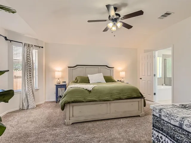 a bedroom with a bed chandelier and window