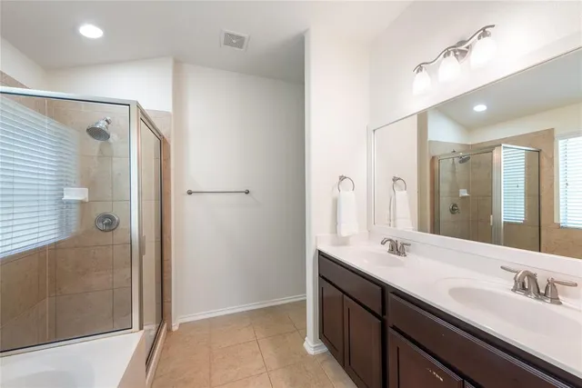 a bathroom with a double vanity sink a large mirror and shower