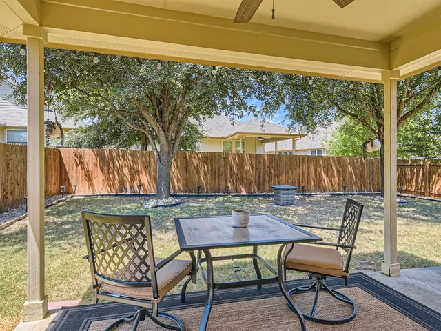 a view of a house with backyard and sitting area